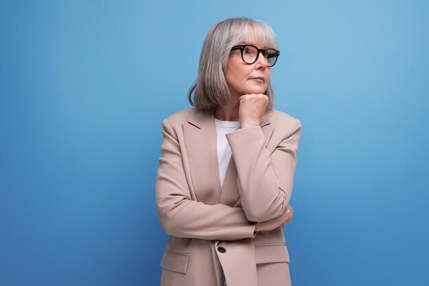 Retrato de una esperanzada mujer de mediana edad vestida de negocios en un estudio con espacio para copiar