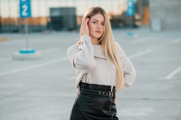 Retrato de estilo de vida al aire libre de una chica rubia impresionante