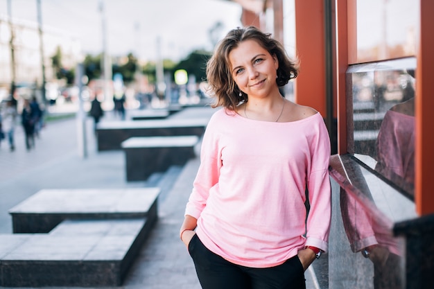 Retrato de estilo de vida de alegre joven con estilo caucásica mujer morena en la calle de verano.