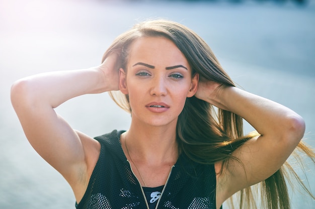 Retrato de estilo de vida de una chica hermosa con el pelo largo en un día soleado