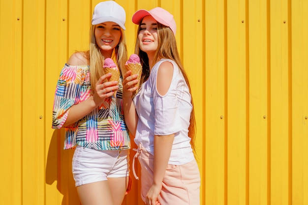 Retrato de estilo de vida de dos hermosas amigas hipster con elegantes trajes brillantes