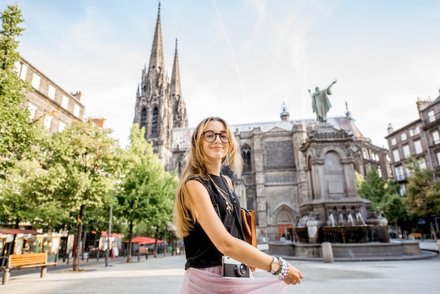 Retrato de estilo de vida de una mujer que viaja frente a la famosa catedral de la ciudad de Clermont-Ferrand en Francia