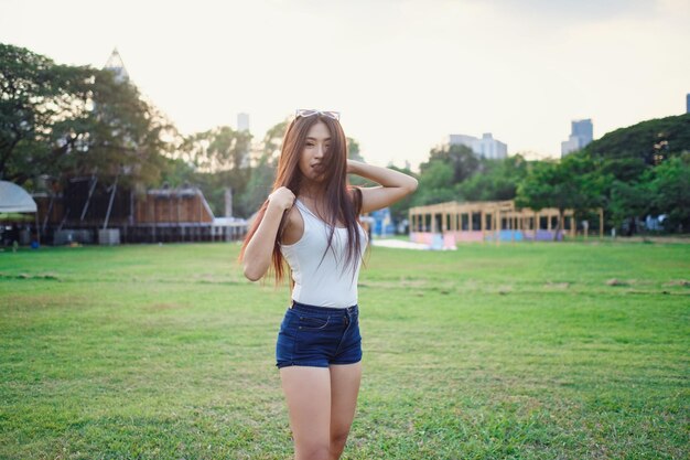 Retrato de estilo de vida soleado de verano de una joven hipster con estilo caminando por la calle con un lindo atuendo de moda Jóvenes mujeres asiáticas viajeras turísticas sonriendo en la moda callejera de bangkok