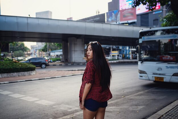 Retrato de estilo de vida soleado de verano de una joven hipster con estilo caminando por la calle con un lindo atuendo de moda Jóvenes mujeres asiáticas viajeras turísticas sonriendo en la moda callejera de bangkok