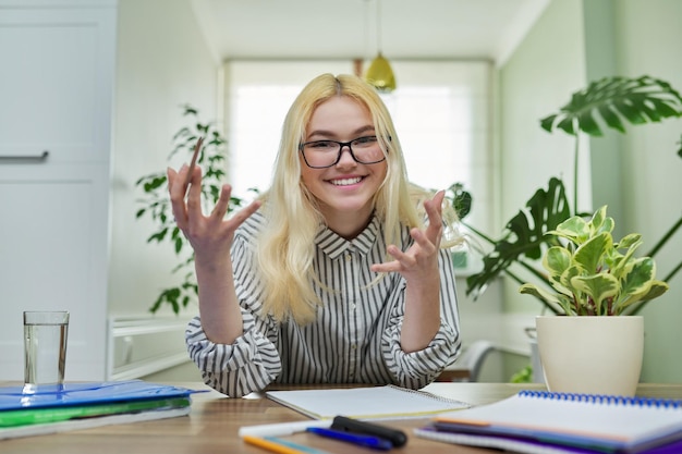 Retrato de una estudiante adolescente mirando a la cámara hablando sonriendo