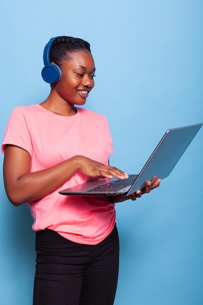 Retrato de estudiante afroamericano con auriculares escuchando música