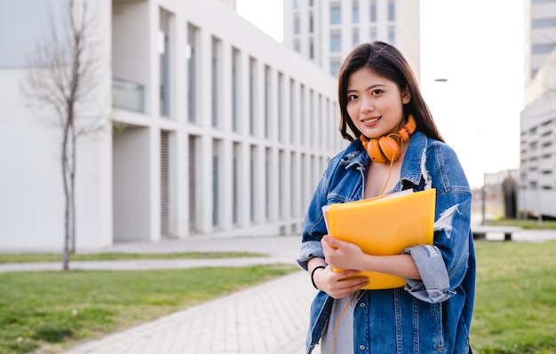 Retrato de un estudiante asiático de pie al aire libre en el concepto de educación del campus universitario