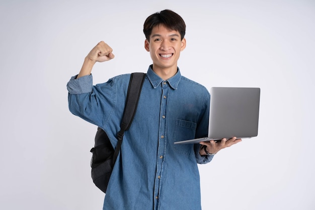 Retrato de un estudiante asiático usando una computadora portátil sobre fondo blanco