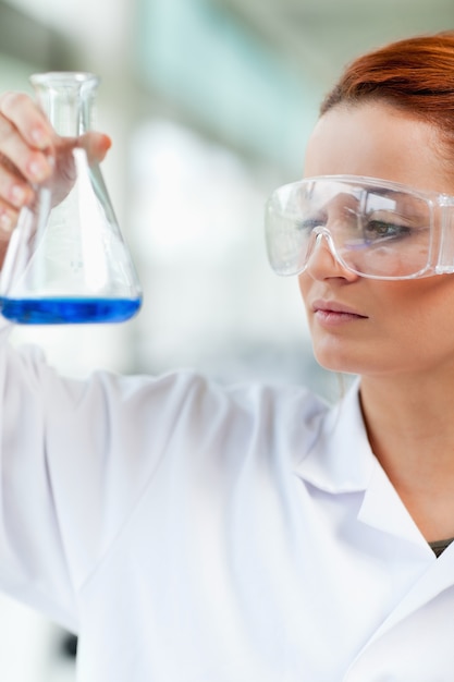 Retrato de un estudiante de ciencias mirando un matraz Erlenmeyr