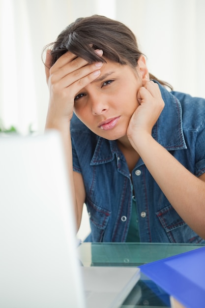 Foto retrato de una estudiante con dolor de cabeza