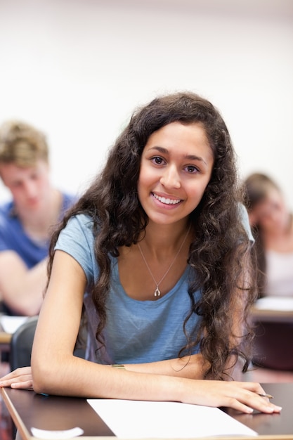 Foto retrato de un estudiante feliz trabajando en una tarea