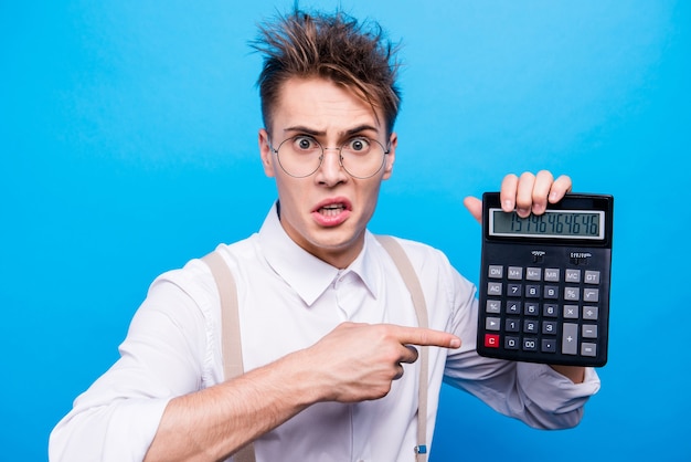 Retrato de estudiante guapo posando con una calculadora