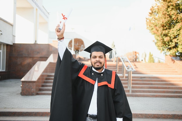 Retrato de estudiante indio exitoso en toga de graduación