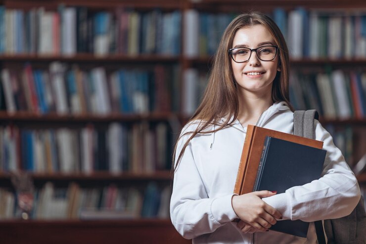 Retrato de estudiante con libros en la biblioteca