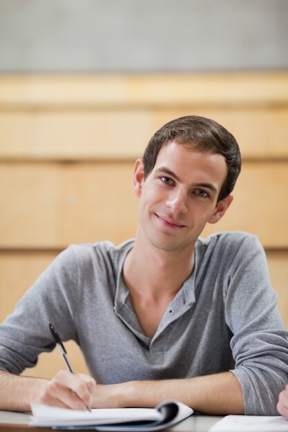 Retrato de un estudiante masculino con una pluma