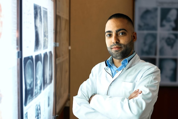 Retrato de estudiante de medicina masculino mexicano de pie cerca de la pantalla de rayos x