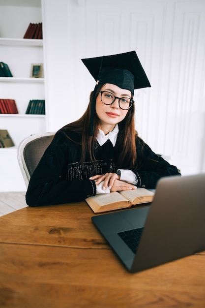 Retrato de estudiante de mujer caucásica joven confía en biblioteca, celebrando la graduación universitaria.