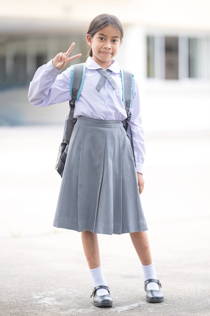 Retrato de estudiante de niños en uniforme y mochila Mirando a la cámara volviendo a la escuela después de la cuarentena y el encierro del covid-19. Concepto De Regreso A La Escuela Stock Photo