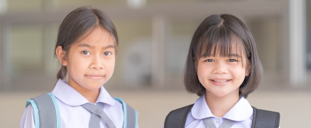 Retrato de estudiante de niños en uniforme y mochila Mirando a la cámara volviendo a la escuela después de la cuarentena y el encierro del covid-19. Concepto De Regreso A La Escuela Stock Photo