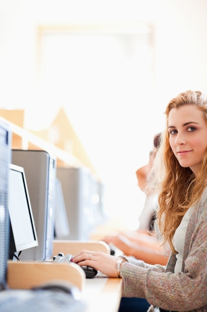 Retrato de un estudiante posando con una computadora