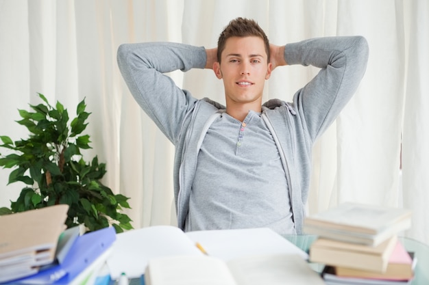 Retrato de un estudiante que se extiende mientras que mira lejos