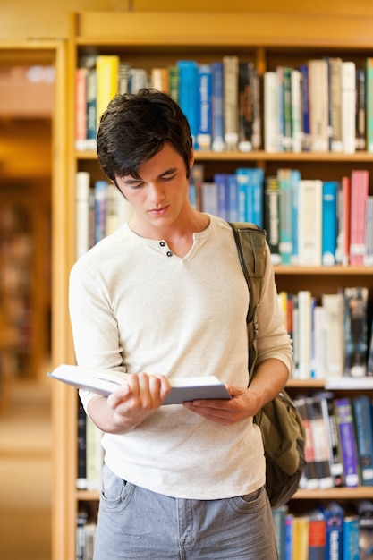 Retrato de un estudiante serio leyendo un libro