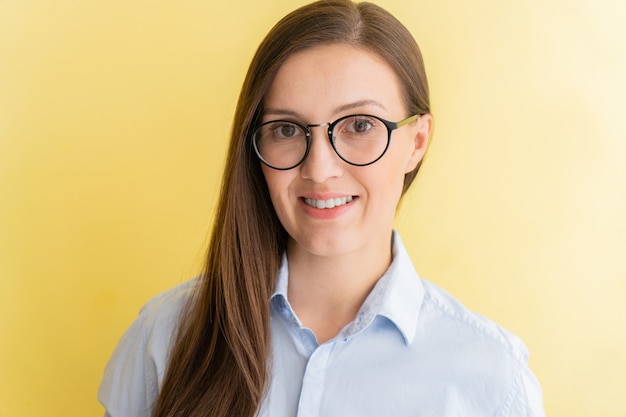 Retrato de estudiante tártaro con gafas sonriendo aislado sobre fondo amarillo