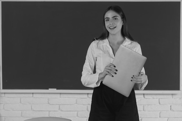 Retrato de una estudiante universitaria sosteniendo una computadora portátil en la escuela o una estudiante universitaria con pc te