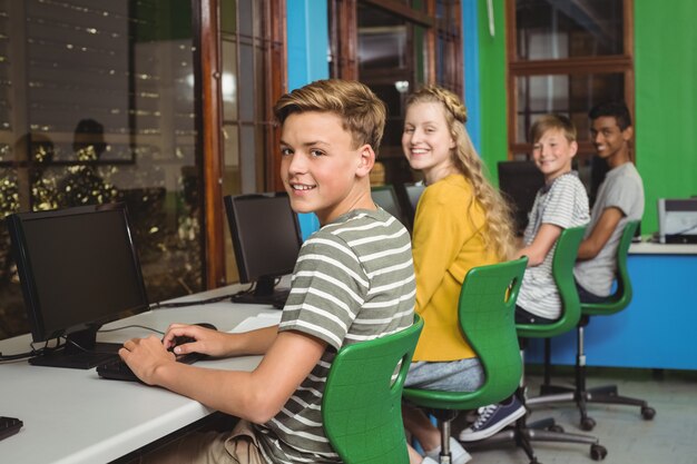 Retrato de estudiantes sonrientes que estudian en el aula de informática