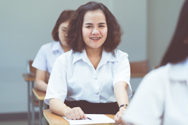 Retrato de estudiantes universitarios asiáticos que estudian y toman nota en el aula