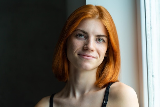 El retrato de estudio de una chica pelirroja con un fondo negro