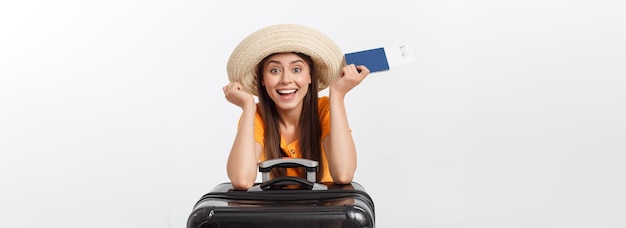 Retrato de estudio de concepto de viaje de mujer joven y bonita con pasaporte y equipaje aislado en blanco