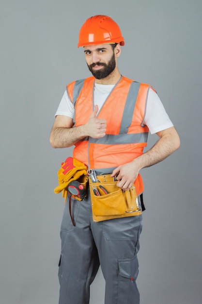 Retrato de estudio de un constructor sobre un fondo gris