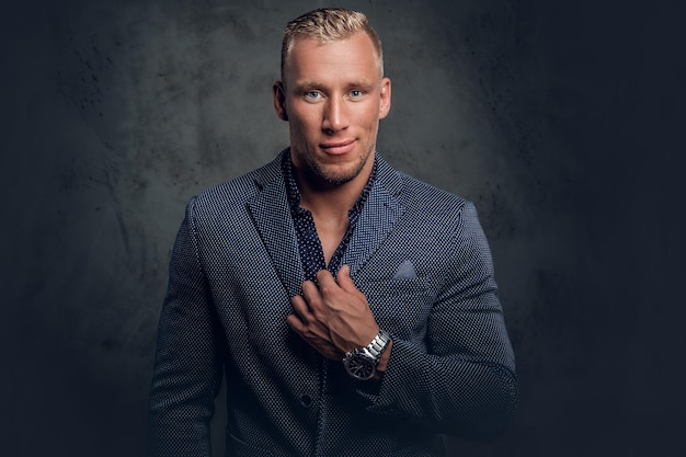 Retrato de estudio de un elegante hombre rubio vestido con un traje azul.