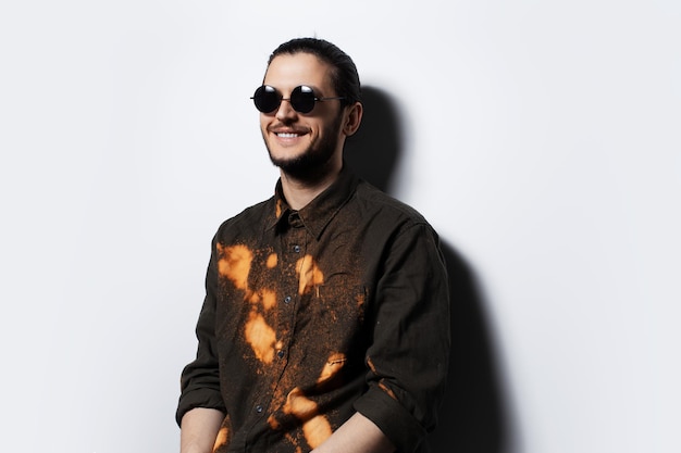 Retrato de estudio de felicidad hombre con gafas de sol sobre fondo blanco.