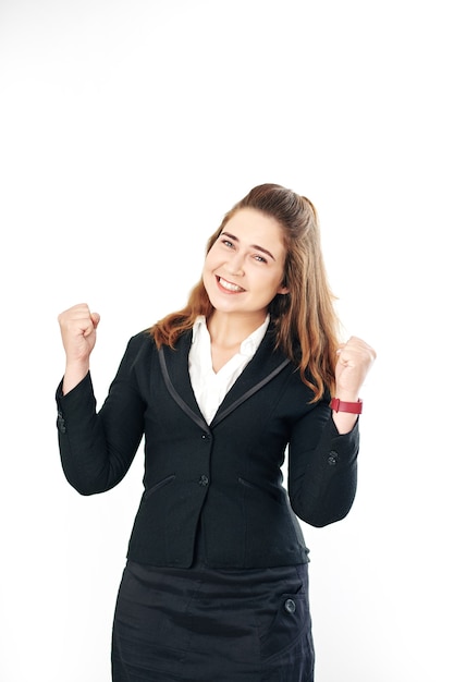 Retrato de estudio de feliz empresaria joven celebrando el éxito o la victoria y haciendo golpe de puño