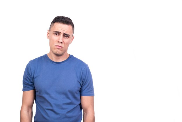 Retrato de estudio con fondo blanco de un hombre de pie con expresión triste