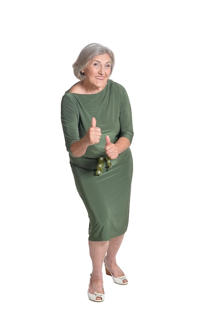 Retrato de estudio de hermosa mujer mayor en vestido verde aislado sobre fondo blanco.