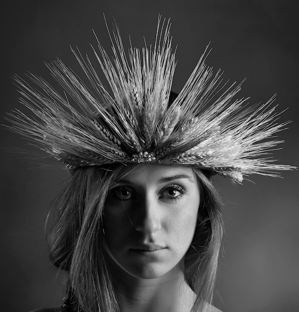 Retrato de estudio de una hermosa niña con una corona hecha con gavillas de trigo