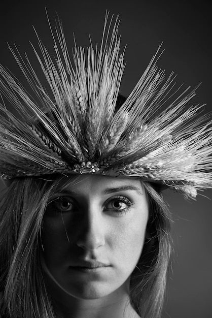 Foto retrato de estudio de una hermosa niña con una corona hecha con gavillas de trigo