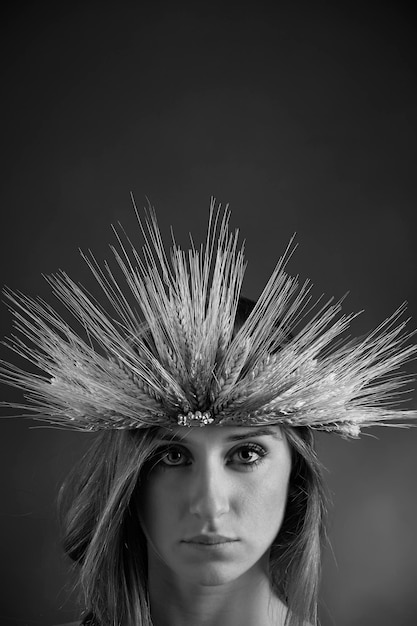 Retrato de estudio de una hermosa niña con una corona hecha con gavillas de trigo