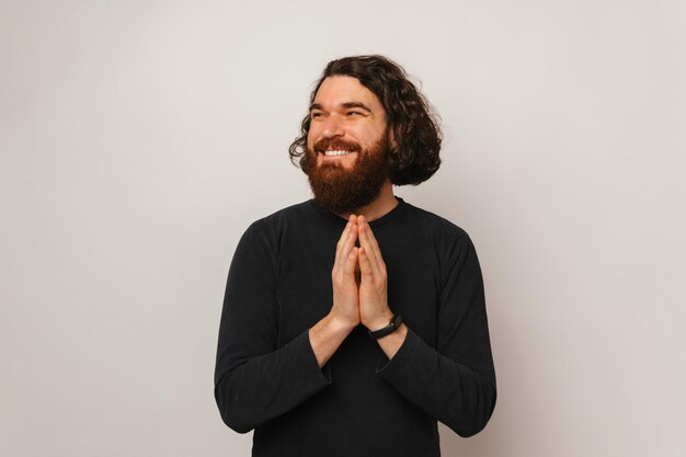 Retrato de estudio de un hombre barbudo astuto sonriente que planea algo divertido