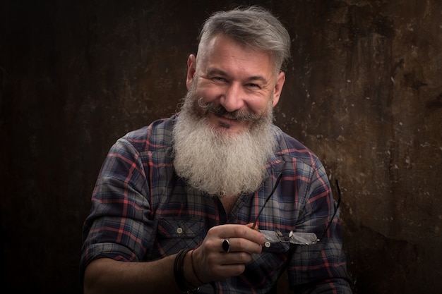 Retrato de estudio de un hombre barbudo de mediana edad canoso sonrisas