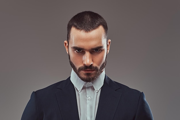 Retrato de estudio de un hombre brutal barbudo. Aislado en un fondo gris.