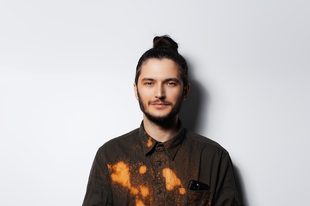 Retrato de estudio de hombre serio con brazos cruzados y moño en blanco