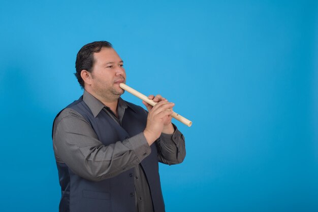 Retrato de estudio de un hombre tocando una grabadora Fondo azul con espacio de copia