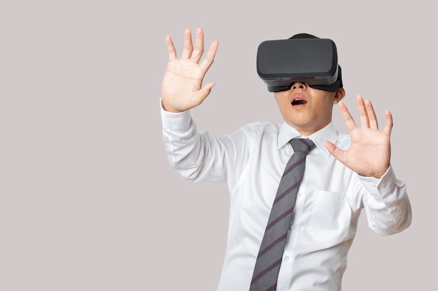 Retrato de estudio hombre vestido con auriculares VR aislado sobre fondo gris Gafas de realidad virtual Tecnología juegos entretenimiento y personas concepto copia espacio