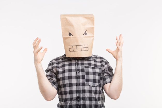 Retrato de estudio de hombres blancos enojados en máscara de bolsa de papel en la cabeza levantando las manos