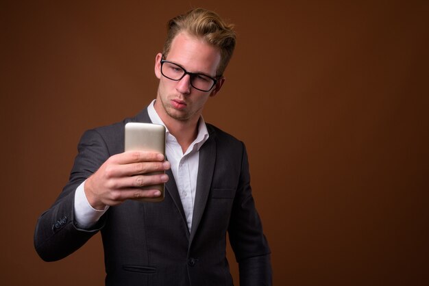 Retrato de estudio de joven empresario guapo con teléfono