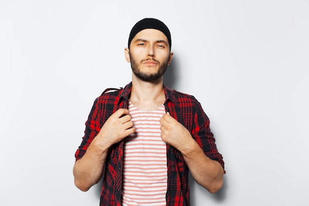 Retrato de estudio de un joven genial con ropa informal roja de fondo blanco